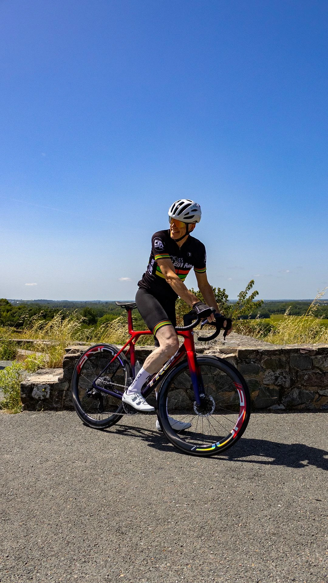 Photo d'un cycliste Cycles Plein Air sur le vélo Trek Madone SLR7 AXS violet et rouge